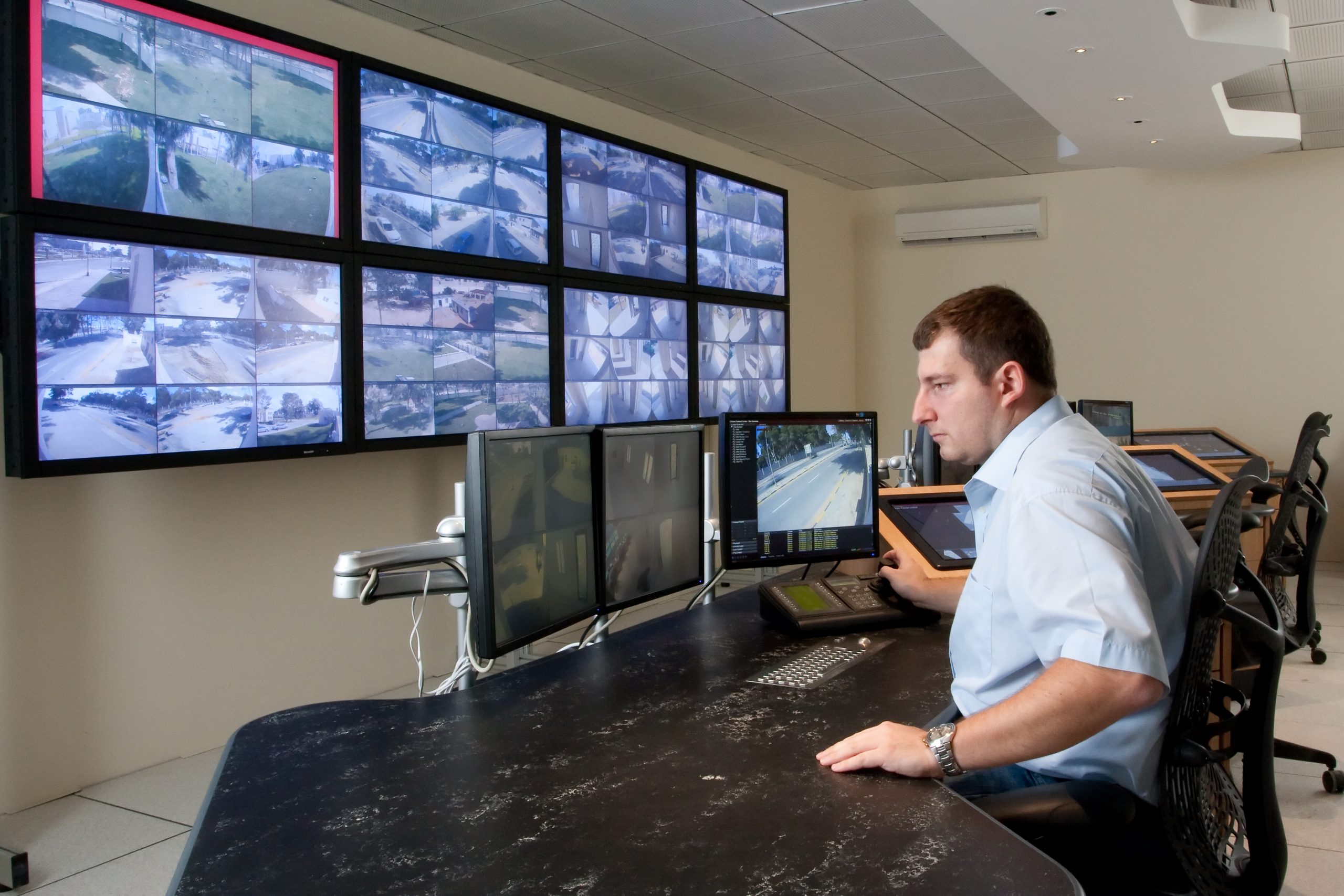 Man monitoring cctv cameras in modern control room