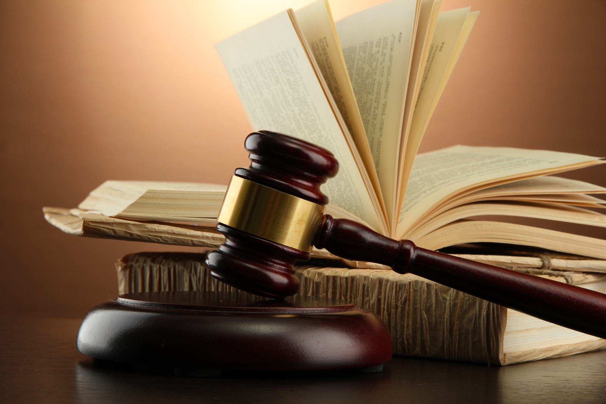 wooden gavel and books on wooden table,on brown background