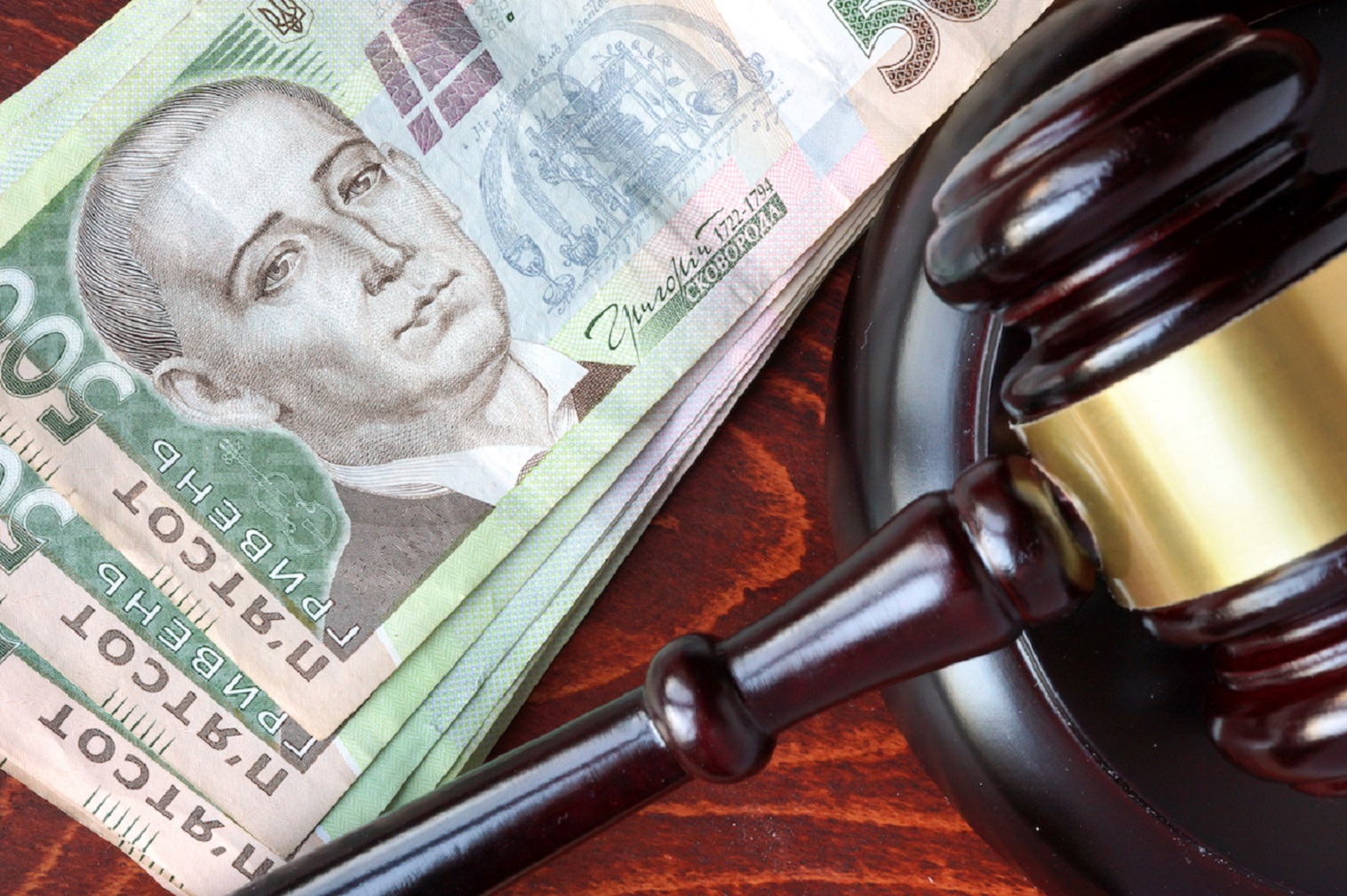 Gavel and Ukrainian hryvnias  on a wooden table.