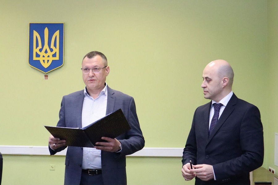 Олеександр Дзюбенко, на фото тримає папку