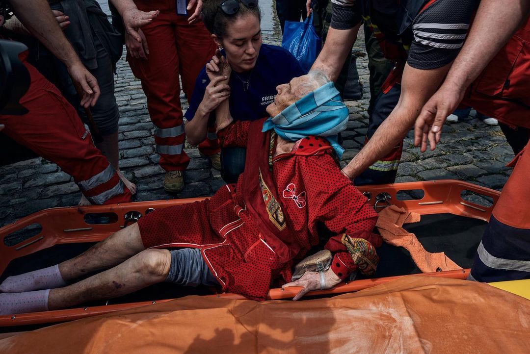 Ілюстративна світлина. Робітники червоного хреста надають допомогу літній жінці, якій стало погано під час евакуації у Херсоні