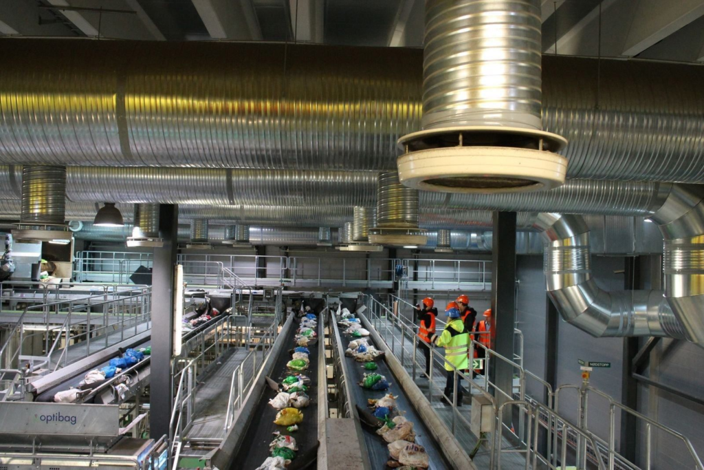 Сміттєпереробний завод – це підприємство, яке використовує різні технології для переробки твердих побутових відходів (ТПВ). Основні функції сміттєпереробного заводу: Сортування: Відходи сортуються на різні фракції, такі як папір, картон, пластик, скло, метал, органічні відходи тощо. Переробка: Сортовані відходи переробляються на нову продукцію. Наприклад, папір можна переробити на картон або туалетний папір, пластик – на нові пластикові вироби, а скло – на склотару або будівельні матеріали. Утилізація: Відходи, які неможливо переробити, утилізуються безпечним для довкілля способом. Наприклад, їх можна спалити в спеціальних печах з жорстким контролем викидів або захоронити на спеціальних полігонах. Переваги сміттєпереробних заводів: Зменшення кількості відходів, що захоронюються на полігонах: Це допомагає зберегти цінні земельні ресурси та зменшити забруднення ґрунту та ґрунтових вод. Виробництво енергії: Деякі сміттєпереробні заводи спалюють відходи для виробництва електроенергії або тепла. Вторинна сировина: Переробка відходів на нову продукцію допомагає зберегти природні ресурси та зменшити забруднення довкілля. Створення робочих місць: Сміттєпереробні заводи створюють робочі місця в сфері збирання, сортування, переробки та утилізації відходів. Недоліки сміттєпереробних заводів: Висока вартість будівництва та експлуатації: Будівництво та експлуатація сміттєпереробного заводу може бути дорогим. Забруднення довкілля: Деякі сміттєпереробні заводи можуть забруднювати повітря та воду, якщо вони не обладнані належним чином системами очищення. Не всі відходи можна переробити: Деякі відходи, такі як небезпечні відходи, неможливо переробити на безпечних для довкілля умовах. В Україні наразі діє декілька сміттєпереробних заводів: Київський сміттєспалювальний завод "Енергія" Львівський сміттєпереробний завод Одеський сміттєпереробний комплекс Дніпровський сміттєпереробний завод Важливо зазначити, що сміттєпереробка – це лише один із компонентів комплексної системи поводження з відходами.