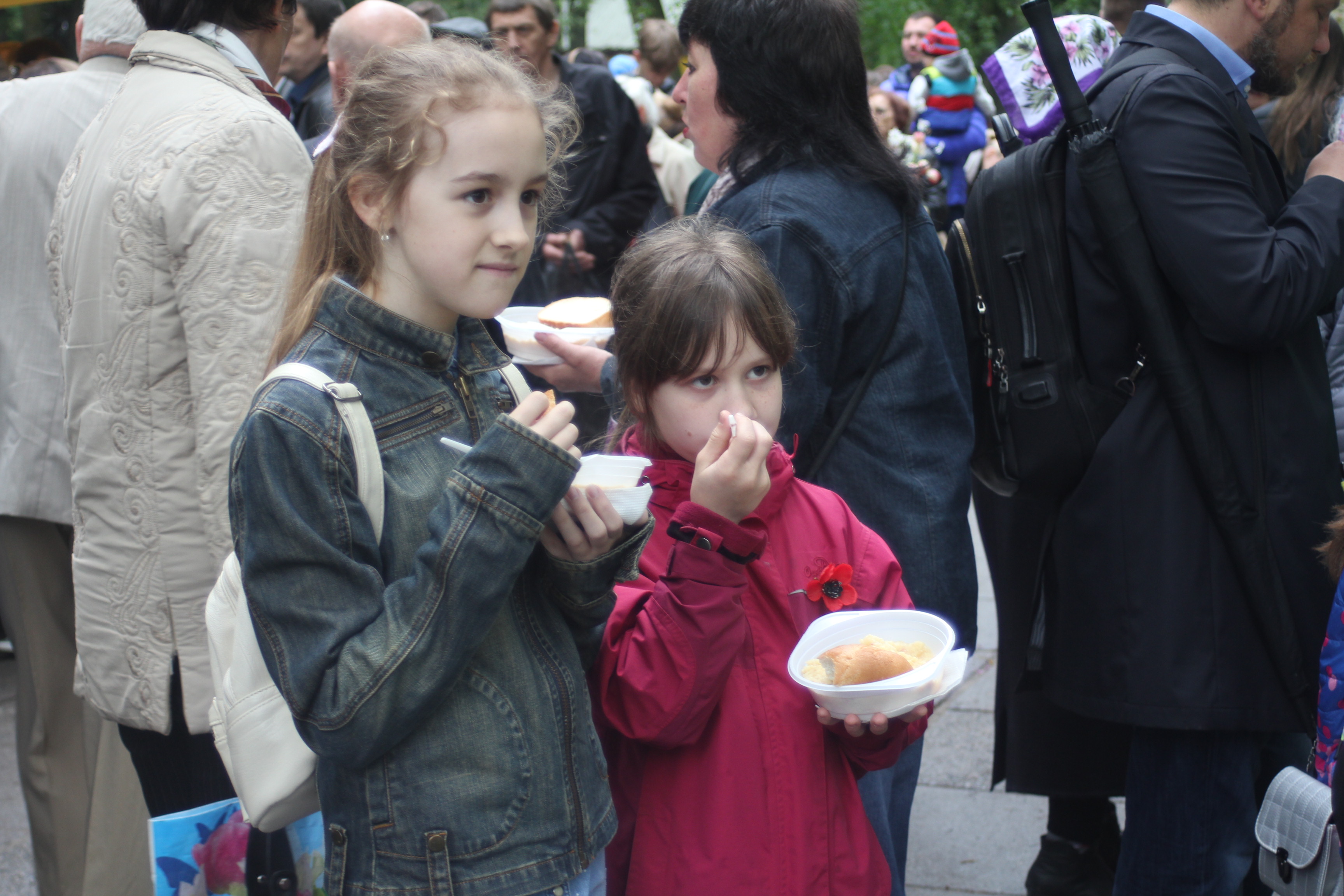 Діти смакують кашею у парку