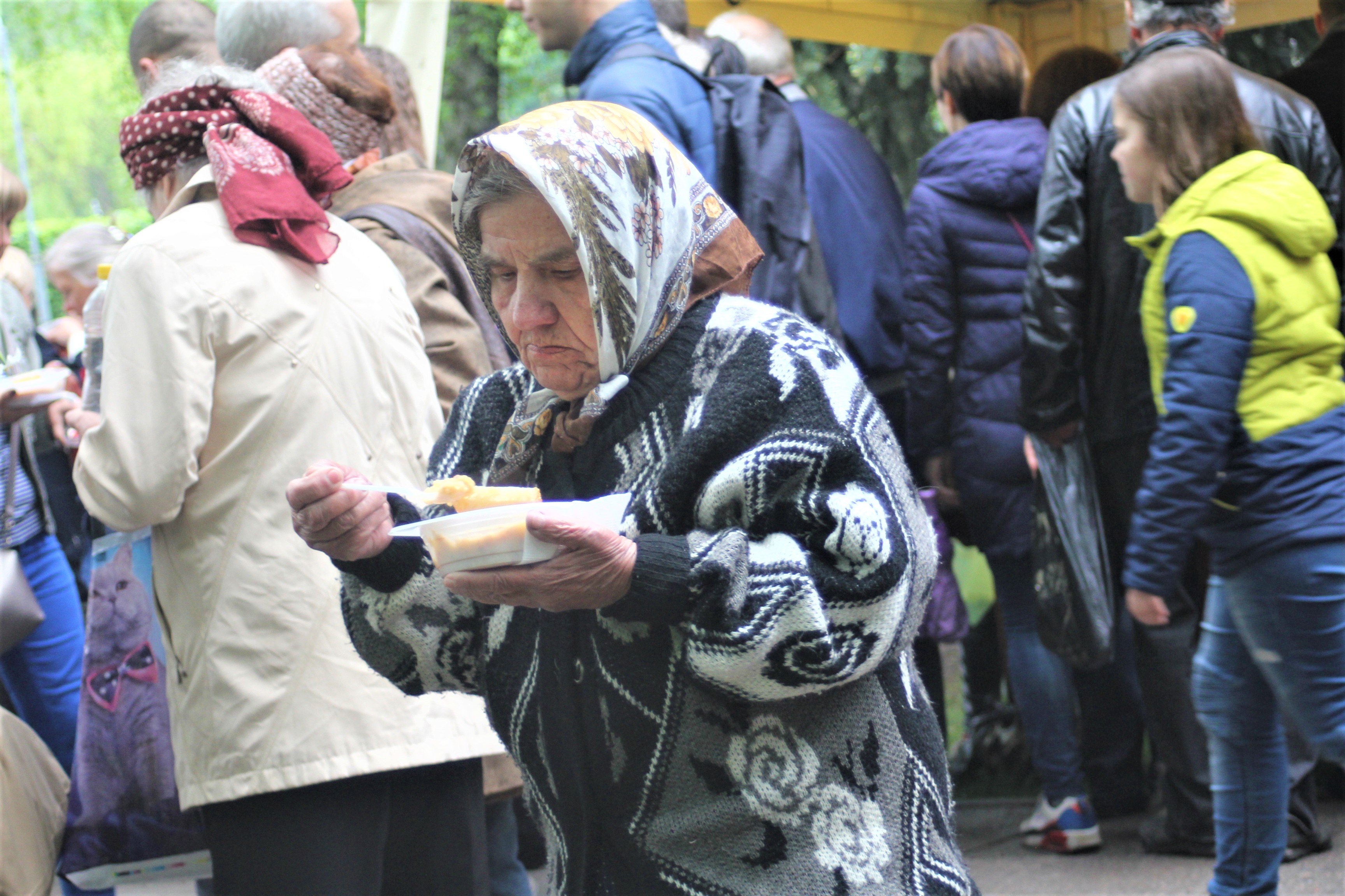 жінка смакує кашею у парку